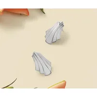 Two translucent gray shell-shaped objects arranged on a pale yellow background with colorful flower petals visible at the edges.