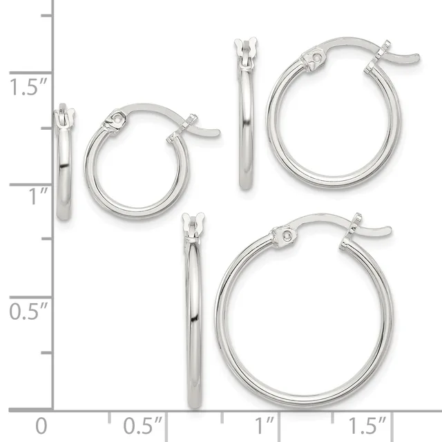 Three pairs of polished silver-toned hoop earrings in graduated sizes displayed on a measurement scale, ranging from approximately one inch to one and one-half inches in diameter.