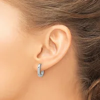 A person wearing a small silver hoop earring in their earlobe, shown from the side profile of their ear and neck.