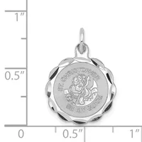 A silver round scalloped-edge pendant with engraved religious imagery and text, shown with a measurement scale indicating its size is approximately one inch in diameter.