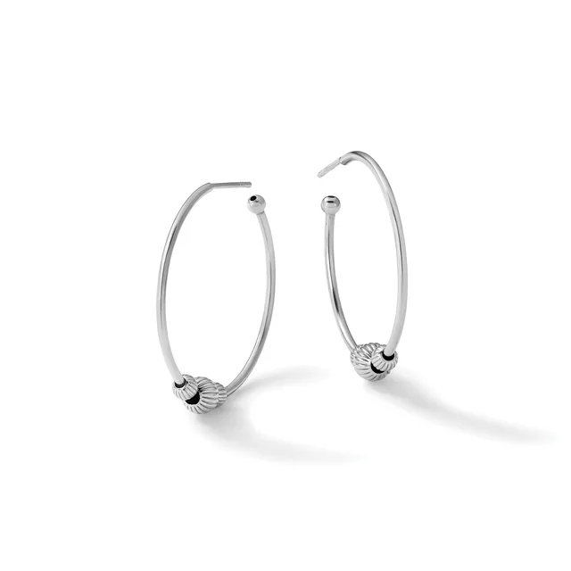 A pair of silver hoop earrings with textured spherical bead accents near the posts, displayed against a white background.