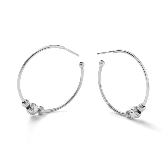 A pair of silver hoop earrings with textured spherical beads positioned near the bottom of each hoop, displayed against a white background.
