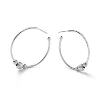 A pair of silver hoop earrings with textured spherical beads positioned near the bottom of each hoop, displayed against a white background.