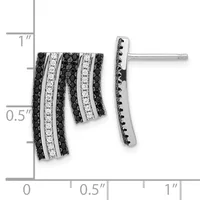 A pair of silver earrings with alternating rows of black and white diamonds in a curved, layered design, shown against a measurement scale.