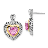 Pair of heart-shaped earrings with pink gemstone centers framed in gold, surrounded by textured silver bands, shown front and side views.