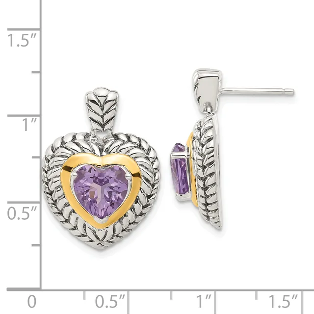Two-tone heart-shaped earrings with purple amethyst centers framed in gold, surrounded by silver leaf-textured bezels, shown front and side view against a measurement scale.