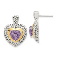 Two-tone heart-shaped earrings with purple faceted amethyst centers framed in gold, surrounded by detailed silver leaf-patterned bezels, shown front and side view.