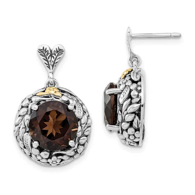 A pair of silver drop earrings with ornate leaf-shaped posts, each featuring a round faceted smoky quartz stone surrounded by a textured silver bezel, shown front and side views.