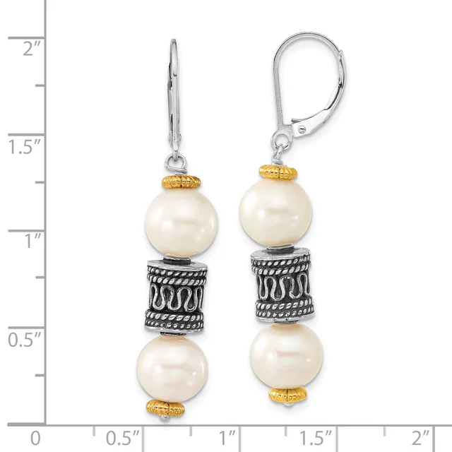 Pair of dangling earrings with cream pearls separated by ornate silver spacer bands with gold-tone caps, shown against a ruler measuring approximately two inches in length.