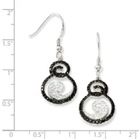 A pair of silver dangle earrings with black crystal-studded circular frames enclosing white crystal-filled spiral designs, displayed against a measurement scale.