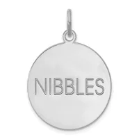 Silver-toned circular pendant with the word "NIBBLES" engraved on its surface, attached to a small loop bail at the top.