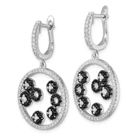 Pair of silver drop earrings with diamond-paved hoops and oval pendants featuring alternating black and white gemstones arranged in a floral pattern around the rim.