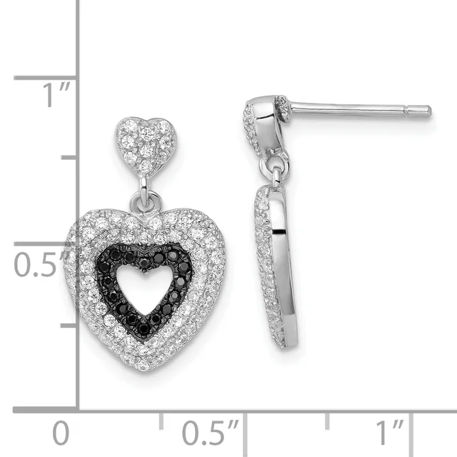 A pair of silver heart-shaped drop earrings with white and black cubic zirconia stones, shown next to a measurement scale indicating approximately one inch in length.