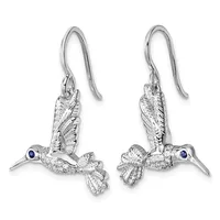 Pair of silver hummingbird dangle earrings with textured wings, small blue sapphire eyes, and fish hook ear wires.