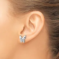 A silver butterfly-shaped stud earring is worn in the earlobe of a person shown in profile view.