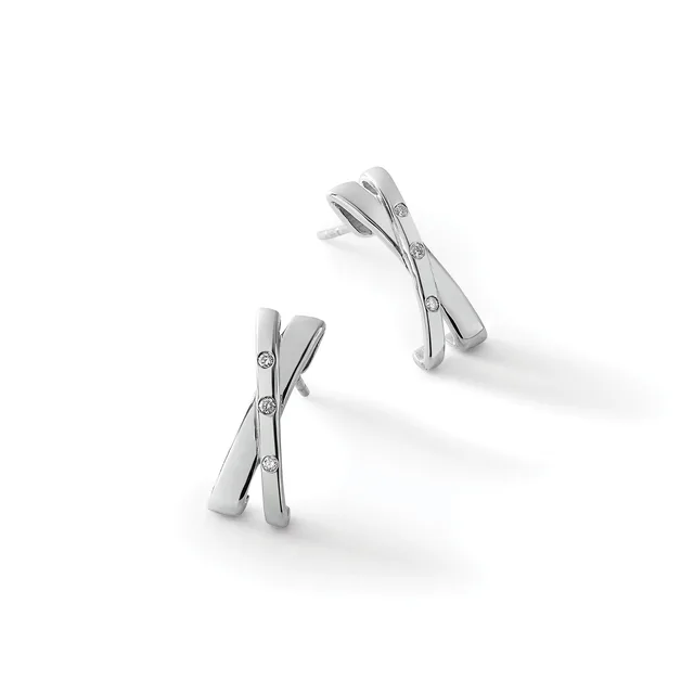 Two silver crossover earrings with small round diamond accents, displayed at angles on a white surface.