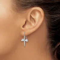 A person wearing silver cross-shaped drop earrings on curved hooks, shown from the side view of their ear and neck.