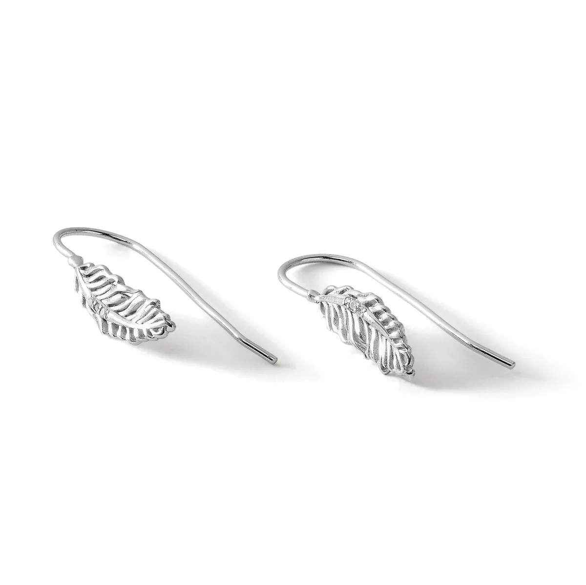 A pair of silver leaf-shaped drop earrings with curved wire hooks, displayed at an angle against a white background.