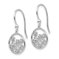 A pair of silver dangle earrings with oval filigree flower medallions suspended from curved ear wires with small beads.