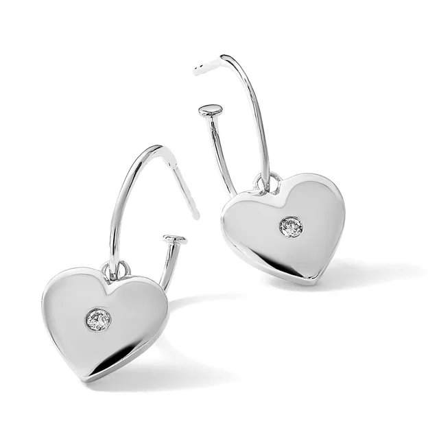 Pair of polished silver heart-shaped earrings with diamond accents, suspended from curved wire hooks.