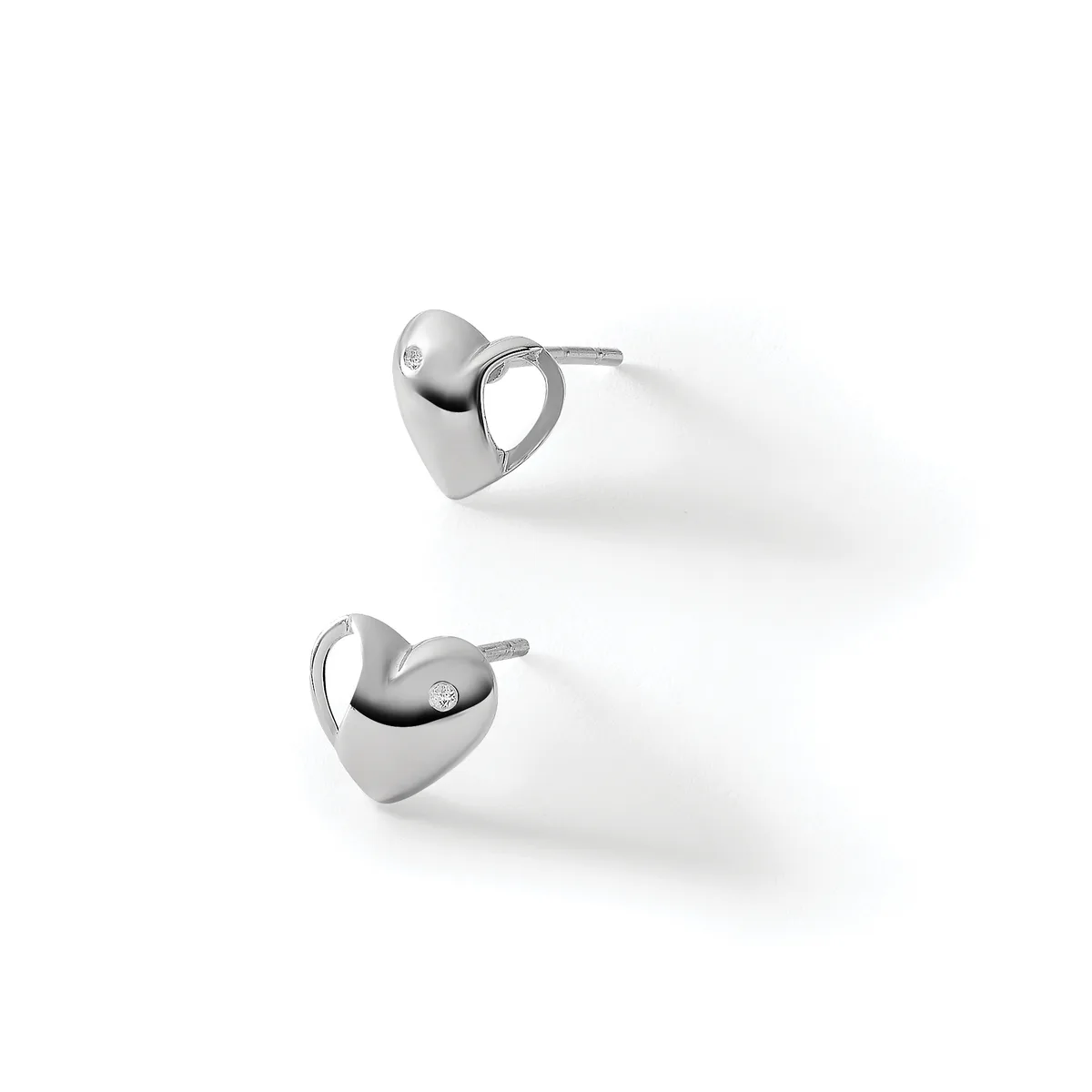 A pair of polished silver heart-shaped stud earrings with small diamond accents, displayed against a white background.