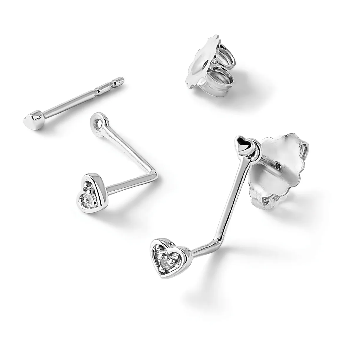 Four silver stud earrings with heart-shaped diamond settings shown from different angles, displayed with matching earring backs.