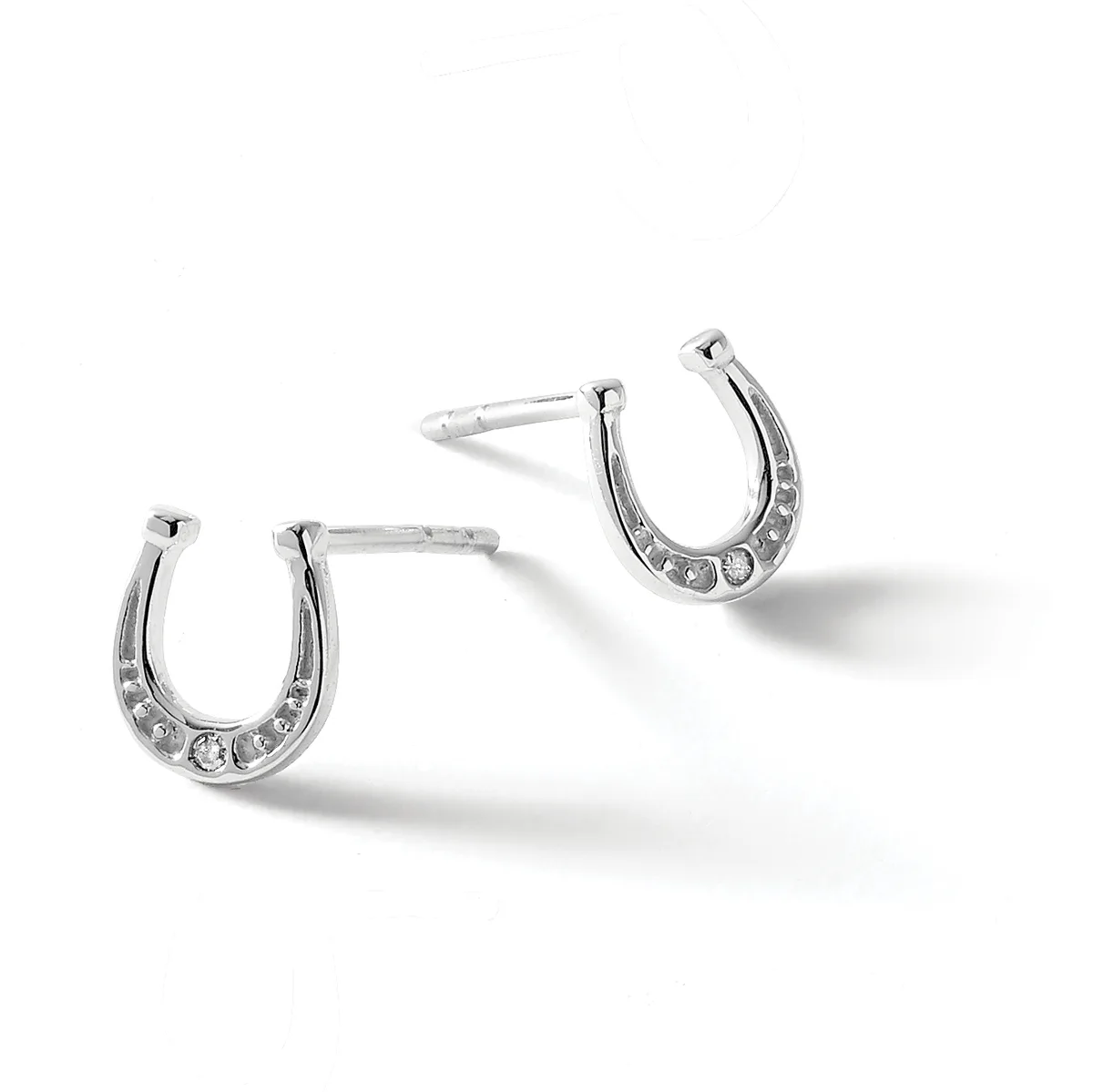 Pair of silver horseshoe-shaped stud earrings set with clear rhinestones along the curved bottom, displayed on a white background.