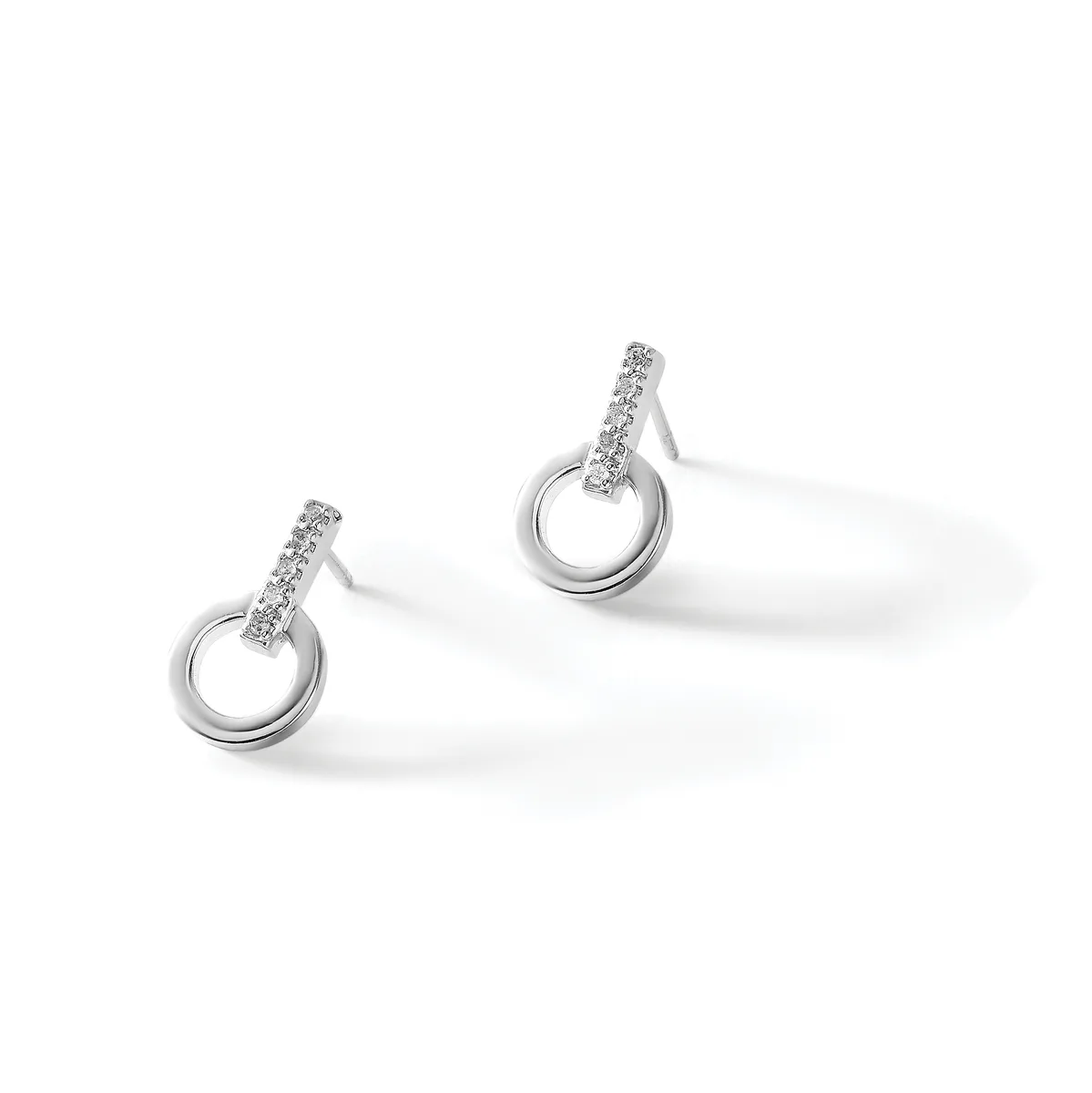 A pair of silver drop earrings with diamond-paved bars suspended from polished circular loops, displayed on a white surface.