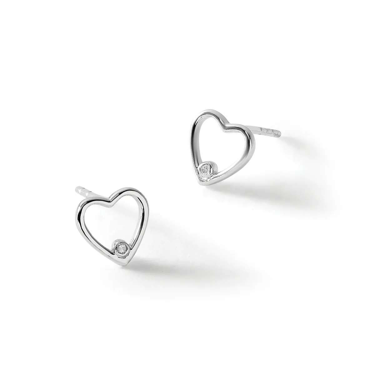 A pair of silver heart-shaped stud earrings with small round diamonds set at the bottom of each heart, displayed against a white background.