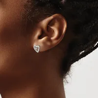 A person wearing a small silver heart-shaped stud earring with a central stone, shown from the side view of their ear.