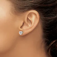 A person wearing a small heart-shaped silver stud earring in their earlobe, shown in profile view.