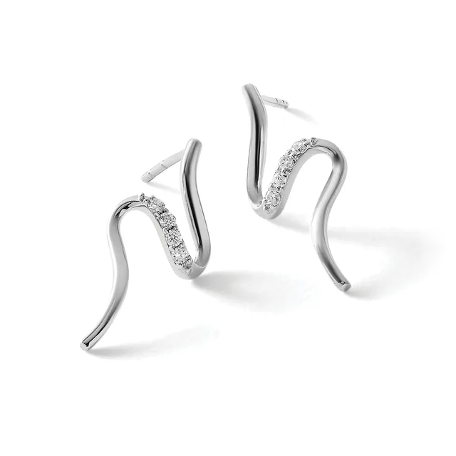 Pair of curved silver hoop earrings with diamond pave detailing on one side of each hoop, shown from a three-quarter view against a white background.