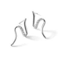 Pair of curved silver hoop earrings with diamond pave detailing on one side of each hoop, shown from a three-quarter view against a white background.