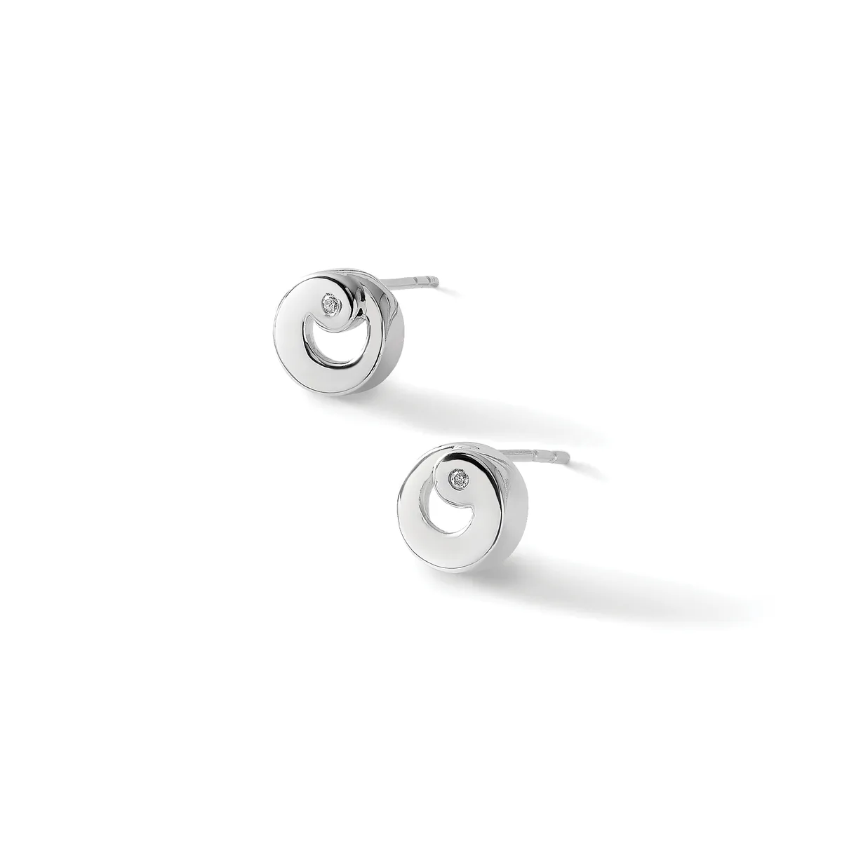 A pair of silver stud earrings with circular faces featuring concentric rings and small diamond accents, displayed against a white background.