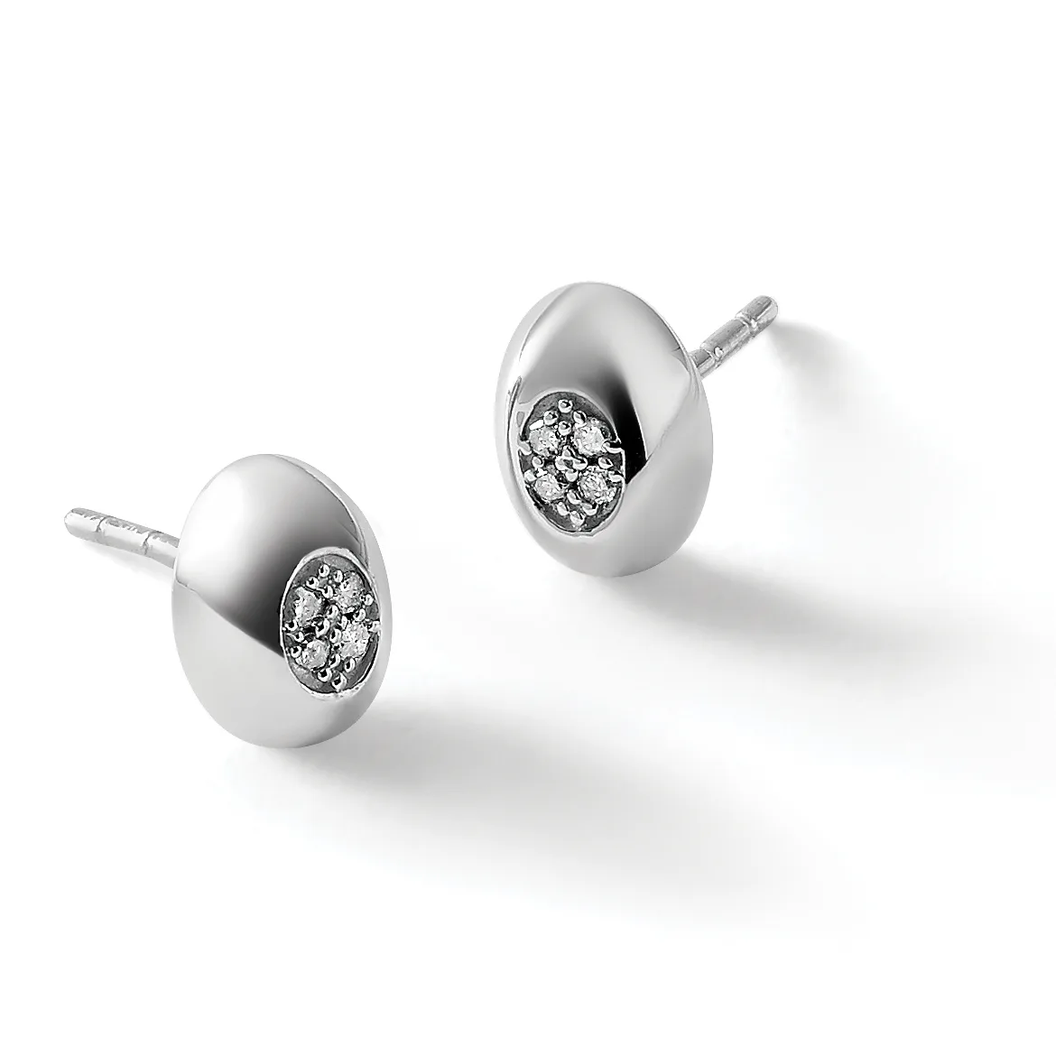 A pair of polished silver oval stud earrings, each featuring a cluster of small diamonds set in the center, shown with posts and backs.