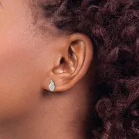 A person wearing a teardrop-shaped diamond stud earring in their pierced earlobe, shown in profile view against their shoulder.