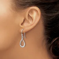 A person wearing silver teardrop-shaped drop earrings with hook closures, shown from the side profile of their ear and neck.