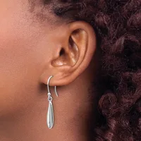 A person wearing a silver teardrop-shaped dangle earring on a curved hook, shown from the side profile of their ear.