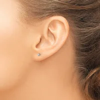 A person's ear with a small diamond stud earring in the lobe, shown in profile view.
