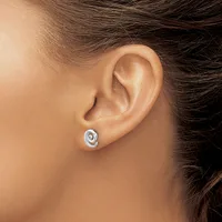 A person wearing a small silver spiral stud earring in their earlobe, shown from a side profile view.