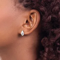 A person wearing a small teardrop-shaped silver earring in their earlobe, shown in profile view with curly dark hair visible.