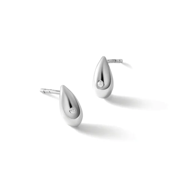 Pair of teardrop-shaped silver stud earrings with small diamond accents, shown on white background with subtle shadows.