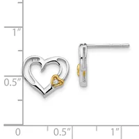 Two-tone heart stud earrings with silver outer heart outline and small gold heart with diamond center, shown next to a measurement ruler.