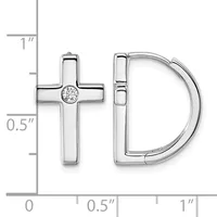 A pair of sterling silver earrings displayed against a measurement scale, consisting of a cross stud with a center diamond and a curved D-shaped hoop.