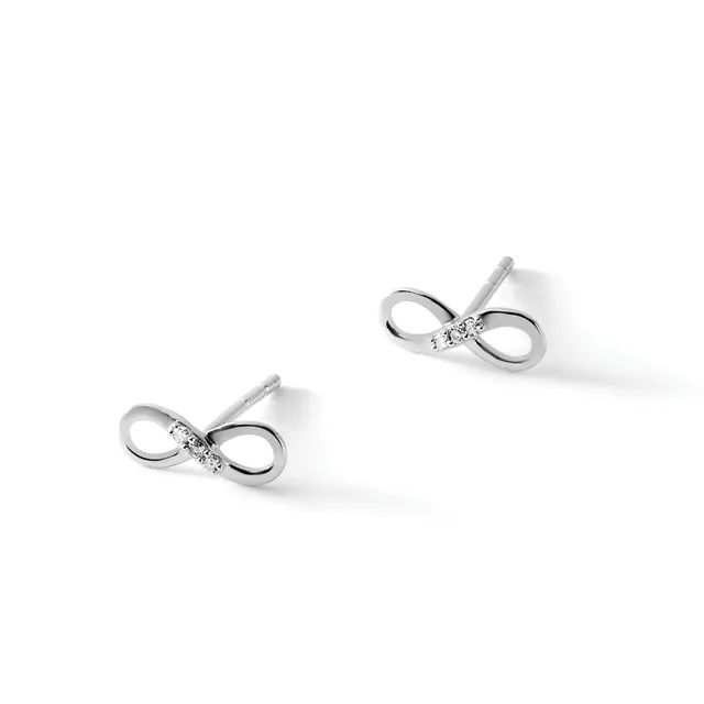 A pair of silver bow-shaped stud earrings with small diamonds or cubic zirconia stones at the center, displayed against a white background.