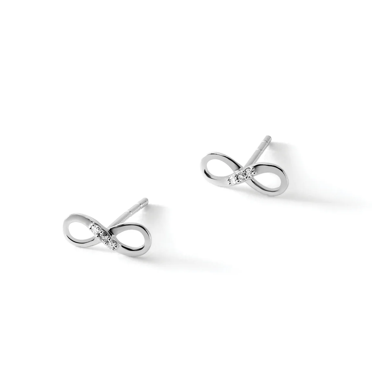 A pair of silver bow-shaped stud earrings with small diamonds or cubic zirconia stones at the center, displayed against a white background.