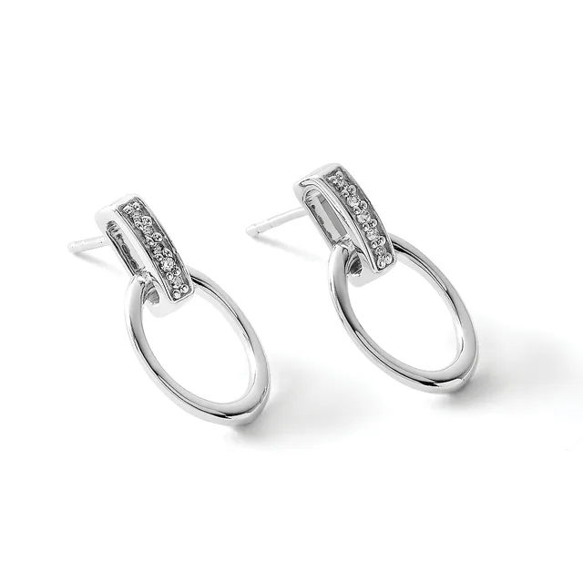 A pair of silver drop earrings with diamond-set rectangular tops and polished oval loops hanging below, shown from a three-quarter view.