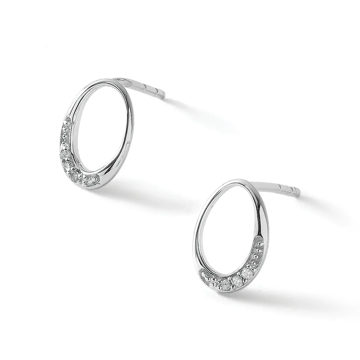 A pair of silver hoop earrings with cubic zirconia stones set along the lower portion of each hoop, shown at angles against a white background.
