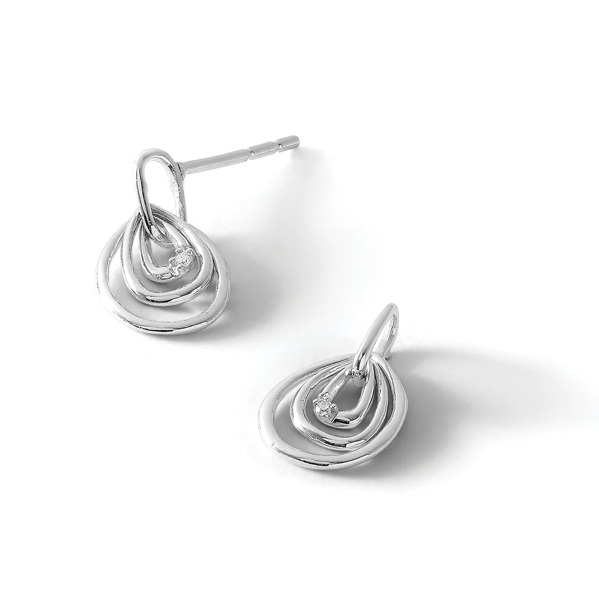 A pair of silver teardrop stud earrings with layered curved bands, shown from front and side angles.