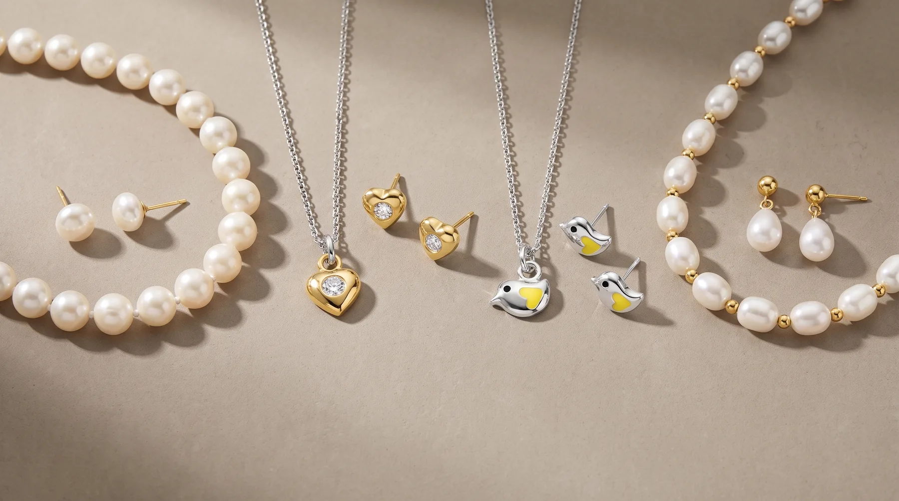 Pearl jewelry displayed on a beige surface including bracelets, stud earrings, and pendant necklaces with gold and silver-tone metal accents and cubic zirconia stones.